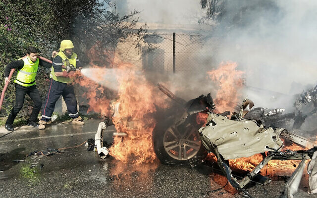 Des pompiers éteignant une voiture en feu après qu'elle a été touchée par une attaque de drone israélien, dans la région de Tyr, au sud du Liban, le 13 mars 2024. (Crédit : AFP) Des pompiers éteignant une voiture en feu après qu'elle a été touchée par une attaque de drone israélien, dans la région de Tyr, au sud du Liban, le 13 mars 2024. (Crédit : AFP)