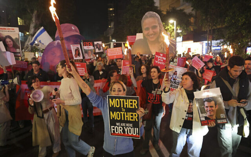 Des manifestants brandissant des pancartes lors d'une manifestation demandant la libération des otages israéliens, à Tel Aviv, le 14 mars 2024. (Crédit : Jack Guez/AFP) Des manifestants brandissant des pancartes lors d'une manifestation demandant la libération des otages israéliens, à Tel Aviv, le 14 mars 2024. (Crédit : Jack Guez/AFP)