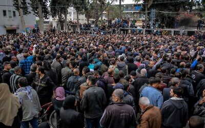Des Palestiniens attendant la distribution de l'aide humanitaire, à Gaza City, le 17 mars 2024. (Crédit : AFP)