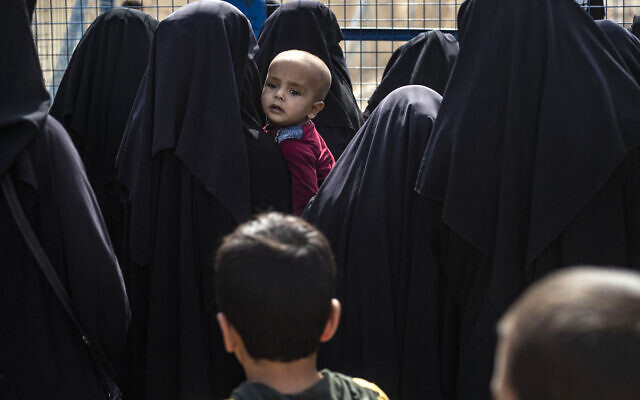 Des femmes se tenant près d'une clôture du camp d'al-Hol, le plus grand des deux camps du nord-est de la Syrie abritant les familles des terroristes de l'État islamique, dans le gouvernorat d'Al-Hasakah, au nord-est de la Syrie, le 10 octobre 2023. (Crédit : Delil Souleiman/AFP) Des femmes se tenant près d'une clôture du camp d'al-Hol, le plus grand des deux camps du nord-est de la Syrie abritant les familles des terroristes de l'État islamique, dans le gouvernorat d'Al-Hasakah, au nord-est de la Syrie, le 10 octobre 2023. (Crédit : Delil Souleiman/AFP)