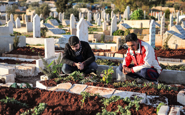 Ahmad al-Hakim (à gauche) prie sur la tombe de son frère Abdul Qader, qui aurait été tué sous la torture alors qu'il était en captivité par Hayat Tahrir Al-Sham. Dans le village de Harbanush, dans la province syrienne d'Idlib, au nord-ouest du pays, le 8 mars 2024. (Crédit : OMAR HAJ KADOUR / AFP) Ahmad al-Hakim (à gauche) prie sur la tombe de son frère Abdul Qader, qui aurait été tué sous la torture alors qu'il était en captivité par Hayat Tahrir Al-Sham. Dans le village de Harbanush, dans la province syrienne d'Idlib, au nord-ouest du pays, le 8 mars 2024. (Crédit : OMAR HAJ KADOUR / AFP)
