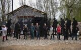 Des volontaires posent avec des silhouettes de soldats de la Seconde Guerre mondiale qui formeront ensemble l'exposition « Standing with Giants » de l’artiste Dan Barton en Normandie, à Cutmill Farm, à Stanton Harcourt, dans le centre de l'Angleterre, le 22 mars 2024. (Crédit : HENRY NICHOLLS / AFP)