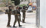 Les forces de sécurité israéliennes inspectent le secteur d'une fusillade à Al-Auja, en Cisjordanie, le 28 mars 2024. (Crédit : AHMAD GHARABLI / AFP)