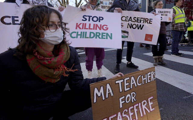 Photo d'illustration : des manifestants anti-israéliens brandissent des panneaux aux abords du domicile de la sénatrice  Elizabeth Warren pendant une manifestation à Cambridge, dans le Massachusetts, le 19 novembre 2023. (Crédit : AP Photo/Steven Senne)
