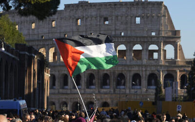 Un drapeau palestinien est brandi devant le Colisée, lors d'un rassemblement de soutien aux Palestiniens à Rome, le 13 janvier 2024. (Crédit : AP Photo/Gregorio Borgia)