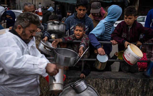 Des Gazaouis faisant la queue pour recevoir de la nourriture gratuite, à Rafah, dans le sud de la bande de Gaza, le 23 février 2024. (Crédit : Fatima Shbair/AP)