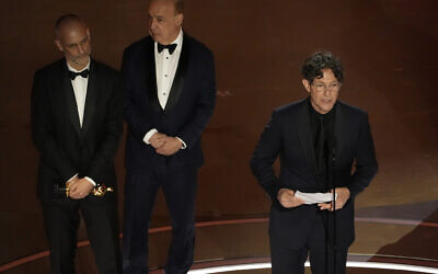 James Wilson, de gauche à droite, Leonard Blavatnik et Jonathan Glazer acceptant le prix du meilleur film international pour "The Zone of Interest" lors de la cérémonie des Oscars, au Dolby Theatre de Los Angeles, le 10 mars 2024. (Crédit : Chris Pizzello/AP)