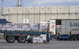 Des camions transportant de l'aide humanitaire pour la bande de Gaza passant par la zone d'inspection au poste-frontière de Kerem Shalom, dans le sud d'Israël, le 14 mars 2024. (Crédit : Ohad Zwigenberg/AP)