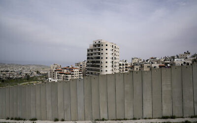 Une vue du camp de réfugiés de Shuafat derrière une partie de la barrière de séparation de la Cisjordanie, à Jérusalem, le 17 mars 2024. (Crédit : Mahmoud Illean/AP)