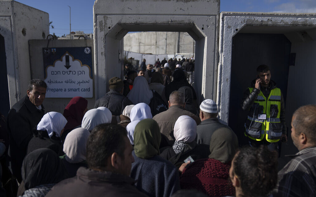 Des Palestiniens traversent le poste de contrôle militaire israélien de Qalandia près de la ville de Ramallah en Cisjordanie vers Jérusalem, pour participer à la prière du vendredi dans l'enceinte de la mosquée Al-Aqsa pendant le mois sacré musulman du Ramadan, le vendredi 22 mars 2024. (Crédit : AP Photo/Nasser Nasser)