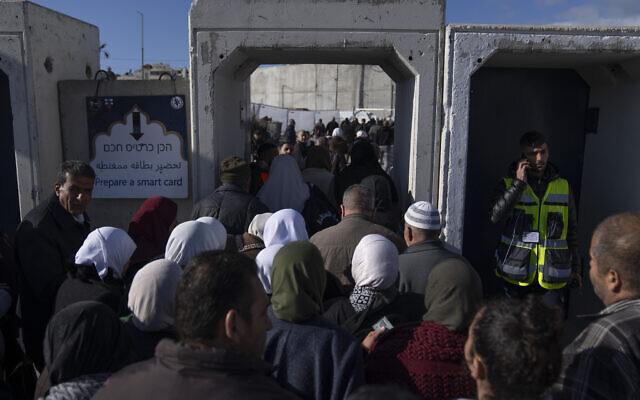Des Palestiniens traversent le poste de contrôle militaire israélien de Qalandia près de la ville de Ramallah en Cisjordanie vers Jérusalem, pour participer à la prière du vendredi dans l'enceinte de la mosquée Al-Aqsa pendant le mois sacré musulman du Ramadan, le vendredi 22 mars 2024. (Crédit : AP Photo/Nasser Nasser)