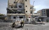 Les forces de sécurité israéliennes examinent un site touché par une roquette tirée depuis le Liban, à Kiryat Shmona, dans le nord d'Israël, le 27 mars 2024. (Crédit : AP Photo/Ariel Schalit)