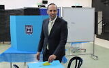 Le candidat à la mairie de Beit Shemesh, Shmuel Greenberg, déposant son bulletin dans l'urne pour le second tour des élections municipales, le 10 mars 2024. (Crédit : Sam Sokol)