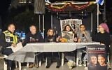 Des membres de familles d'otages retenus en captivité à Gaza depuis le 7 octobre manifestant depuis l’intérieur d'une soucca, à Tel Aviv, le 25 mars 2024. (Crédit : Forum des familles des otages et disparus)