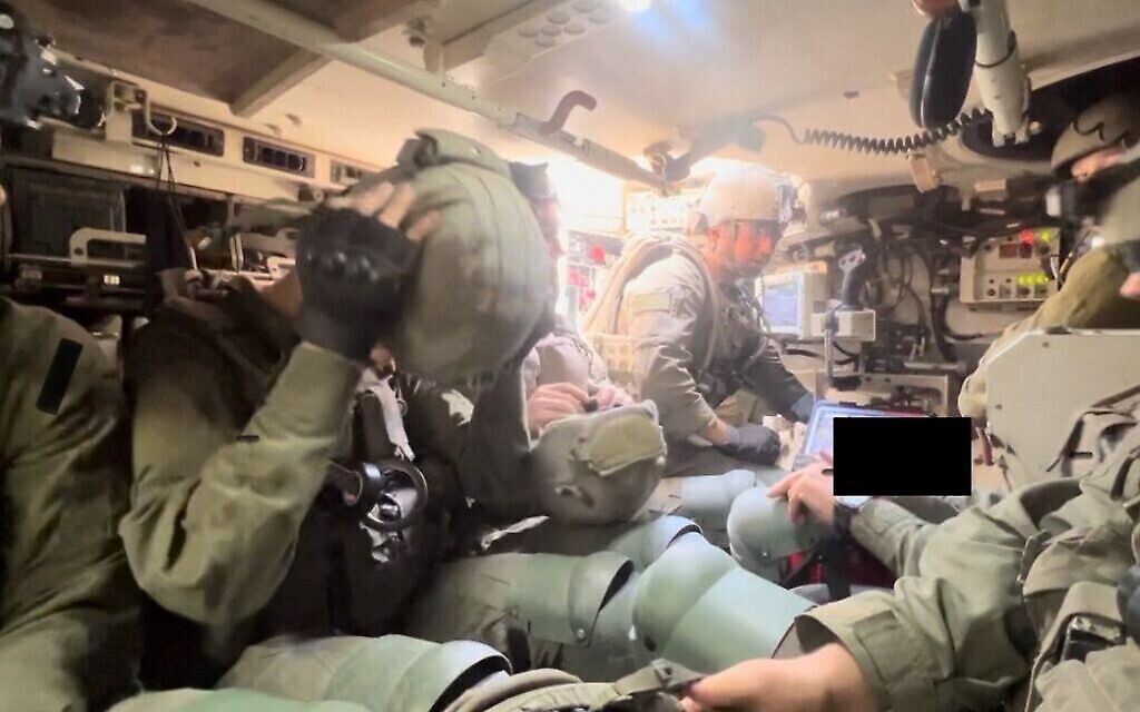 Des soldats du 603e bataillon du génie de combat se préparent à quitter leur véhicule de transport de troupes, le 21 mars 2024. (Crédit : Lazar Berman/The Times of Israel)