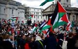 Des militants et partisans pro-palestiniens et anti-Israël brandissant des drapeaux alors qu'ils se rassemblent pour une manifestation ,à Trafalgar Square, dans le centre de Londres, le 30 mars 2024. (Crédit : BENJAMIN CRÉMEL / AFP)