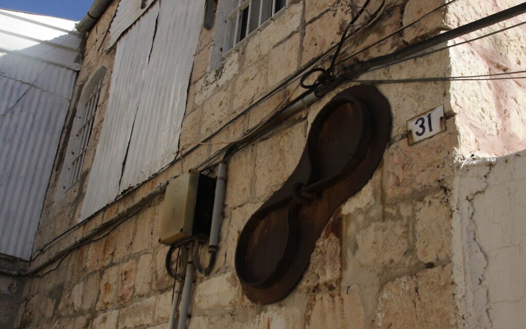 Un signe en forme de huit à l'extérieur d'un bâtiment, dans le quartier de Mishkenot Yisrael, à Jérusalem. (Crédit : Shmuel Bar-Am)
