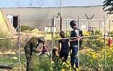 Nasreen Yousef (de dos au centre) filmée par sa fille Shiran, 13 ans, en train de parler à des terroristes du Hamas dans le jardin de leur maison, au moshav Yated, près de la frontière sud de Gaza, le 7 octobre 2023. (Crédit : Capture d'écran/N12/Keshet TV ; utilisée conformément à la clause 27a de la loi sur le droit d'auteur)