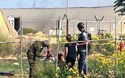 Nasreen Yousef (de dos au centre) filmée par sa fille Shiran, 13 ans, en train de parler à des terroristes du Hamas dans le jardin de leur maison, au moshav Yated, près de la frontière sud de Gaza, le 7 octobre 2023. (Crédit : Capture d'écran/N12/Keshet TV ; utilisée conformément à la clause 27a de la loi sur le droit d'auteur)
