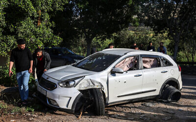 Des hommes palestiniens vérifient une voiture criblée de balles après un raid de Tsahal dans le camp d'al-Faraa près de Tubas en Cisjordanie, le 12 avril 2024. (Crédit : Zain Jaafar/AFP)