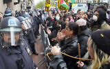 Des policiers new-yorkais en tenue anti-émeute montant la garde alors que des manifestants pro-palestiniens et anti-Israël scandent des slogans à l'extérieur du campus de l'Université Columbia, à New York, le 18 avril 2024. (Crédit : Mary Altaffer/AP)