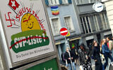 Une croix gammée dessinée sur une affiche électorale de l'Union démocratique du centre (UDC) anti-immigrés, dans le centre de Zurich, le 18 octobre 2003. (Crédit : Jean-Philippe Ksiazek/AFP)