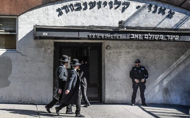Un membre de la police de New York patrouillant devant une synagogue, dans le quartier de Williamsburg, à Brooklyn, à New York, le 13 octobre 2023. (Crédit : Stephanie Keith/Getty Images/AFP)