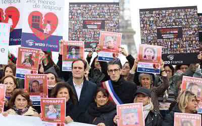 La présidente de Wizo Nathalie Riu-Guez (1g), la journaliste Anne Sinclair (2g), le président du Conseil représentatif des institutions juives françaises (CRIF) Yonathan Arfi (C), le nouveau maire du 16e arrondissement de Paris Jeremy Redler avec des partisans et des proches d'otages israéliens participent à un rassemblement appelé « Les Mères de l'Espoir » pour appeler à la libération des 239 otages détenus par le groupe militant palestinien Hamas à Gaza, à Paris, le 17 novembre 2023. Il reste à ce jour 129 otages aux mains du Hamas et de ses complices. (Crédit : ALAIN JOCARD / AFP)
