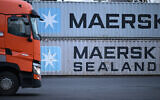Un camion passant devant des conteneurs portant le logo du géant danois du transport maritime Maersk et Maersk Sealand empilés dans une station de transbordement, à Francfort-sur-le-Main, dans l'ouest de l'Allemagne, le 23 janvier 2024. (Crédit : Kirill Kudryavtsev/AFP)