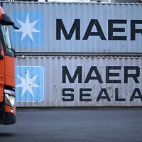 Un camion passant devant des conteneurs portant le logo du géant danois du transport maritime Maersk et Maersk Sealand empilés dans une station de transbordement, à Francfort-sur-le-Main, dans l'ouest de l'Allemagne, le 23 janvier 2024. (Crédit : Kirill Kudryavtsev/AFP)