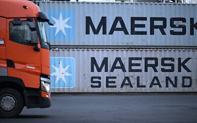 Un camion passant devant des conteneurs portant le logo du géant danois du transport maritime Maersk et Maersk Sealand empilés dans une station de transbordement, à Francfort-sur-le-Main, dans l'ouest de l'Allemagne, le 23 janvier 2024. (Crédit : Kirill Kudryavtsev/AFP)