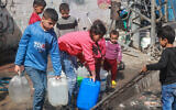 Des enfants palestiniens allant chercher de l'eau à Rafah, dans le sud de la bande de Gaza, le 30 mars 2024. (Crédit : Mohammed Abed/AFP)