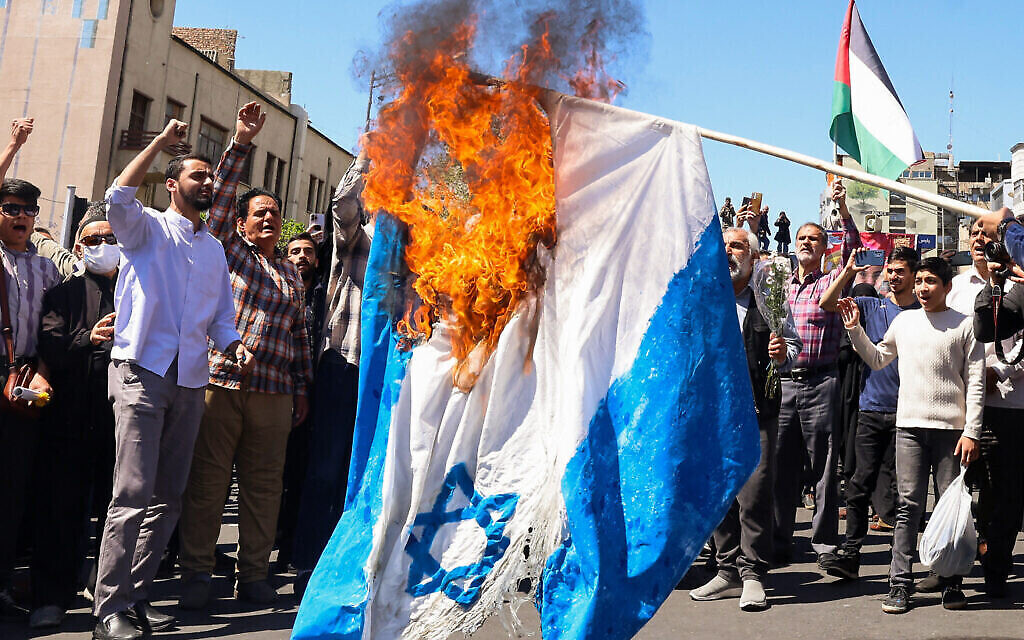 Des manifestants brûlent un drapeau israélien lors des funérailles de sept membres du Corps des gardiens de la révolution islamique tués lors d'une attaque en Syrie, que l'Iran a imputée à Israël, à Téhéran, le 5 avril 2024. (Crédit : Atta Kenare/AFP)