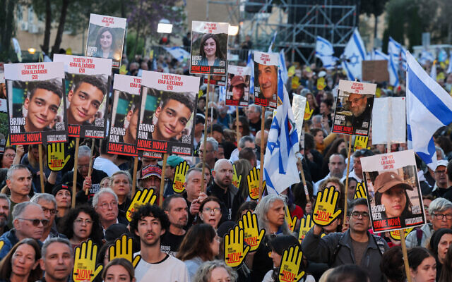 Des parents et des sympathisants des otages détenus à Gaza depuis le massacre du 7 octobre par le Hamas brandissant des pancartes et des drapeaux nationaux lors d'une manifestation devant la Knesset, à Jérusalem, le 7 avril 2024. (Crédit : Menahem Kahana/AFP) Des parents et des sympathisants des otages détenus à Gaza depuis le massacre du 7 octobre par le Hamas brandissant des pancartes et des drapeaux nationaux lors d'une manifestation devant la Knesset, à Jérusalem, le 7 avril 2024. (Crédit : Menahem Kahana/AFP)