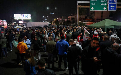 Des partisans du parti chrétien des Forces libanaises bloquent l'autoroute principale Byblos-Beyrouth pour protester contre l'assassinat d'un homme politique local dans la région de Jbeil (Byblos), le 8 avril 2024. (Crédit : JOSEPH EID / AFP)