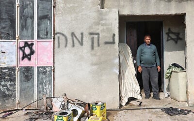 Un slogan indiquant "vengeance" en hébreu et des graffitis représentant des étoiles de David sur la façade d'une maison palestinienne après une attaque présumée de résidents d’implantations israéliens, dans le village d'al-Lubban ash-Sharqiya, au sud de Naplouse, en Cisjordanie, le 11 avril 2024. (Crédit : Zaïn Jaafar/AFP)