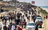 Des Palestiniens déplacés qui empruntent la route côtière de Rashid pour tenter de retourner à la ville de Gaza passent par Nuseirat dans le centre de la bande de Gaza, le 14 avril 2024. (Crédit : AFP)