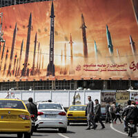 Un panneau montrant des missiles balistiques iraniens, avec un texte en perse disant "Israël est plus faible qu'une toile d'araignée" sur la place Valiasr, dans le centre de Téhéran, le 15 avril 2024. (Crédit :  ATTA KENARE / AFP)