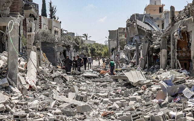 Des Palestiniens fouillent les décombres d'un immeuble détruit du côté oriental du camp de réfugiés de Maghazi dans le centre de Gaza, le 15 avril 2024. (Crédit : AFP)