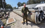 Le porte-parole de l’armée israélienne, le contre-amiral Daniel Hagari, à côté d'un missile balistique iranien tombé en Israël lors d'une visite des médias, à la base militaire de Julis, à proximité de Kiryat Malachi, le 16 avril 2024. (Crédit : Gil Cohen-Magen/AFP)
