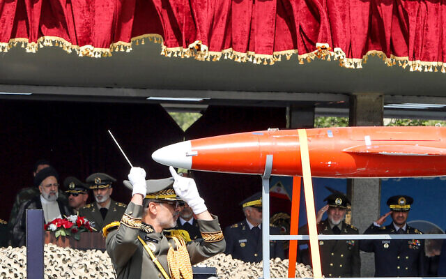 Un camion militaire iranien transportant un drone Arash devant le président Ebrahim Raissi (à gauche) et des officiers de l'armée lors d'un défilé militaire dans le cadre d'une cérémonie marquant la Journée annuelle de l'Armée du pays à Téhéran, le 17 avril 2024. (Crédit : Atta Kenare/AFP)