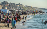Des Palestiniens profitant de la plage à Deir el-Balah, dans le centre de la bande de Gaza, le 17 avril 2024. (Crédit : AFP)