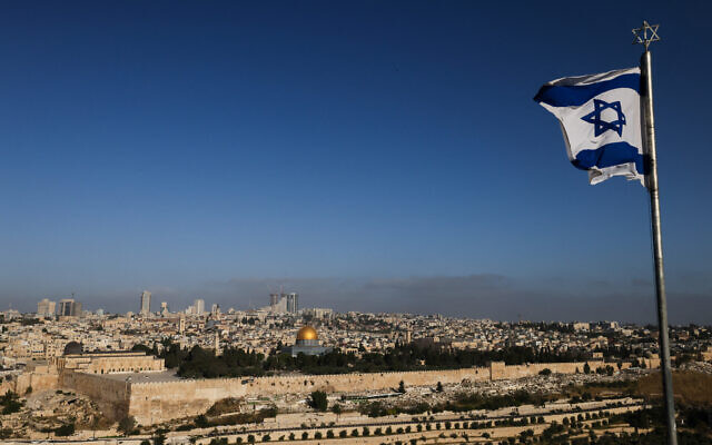 Un drapeau israélien flotte sur le Mont des Oliviers surplombant la mosquée Al Aqsa au sommet du Mont du Temple à Jérusalem le 19 avril 2024. (Crédit : Ahmad GHARABLI/AFP)