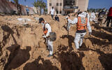 Des travailleurs sanitaires palestiniens recherchant des corps enterrés à l'hôpital Nasser de Khan Younès, dans le sud de la bande de Gaza, le 21 avril 2024. (Crédit : AFP)