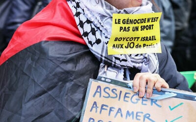 Un manifestant portant un autocollant "le génocide n'est pas un sport, boycottez Israël aux Jeux Olympiques de Paris" lors d'une manifestation "contre les racismes, contre l'islamophobie" à l'appel de diverses organisations à Paris le 21 avril 2024. (Crédit : Alain Jocard/AFP)