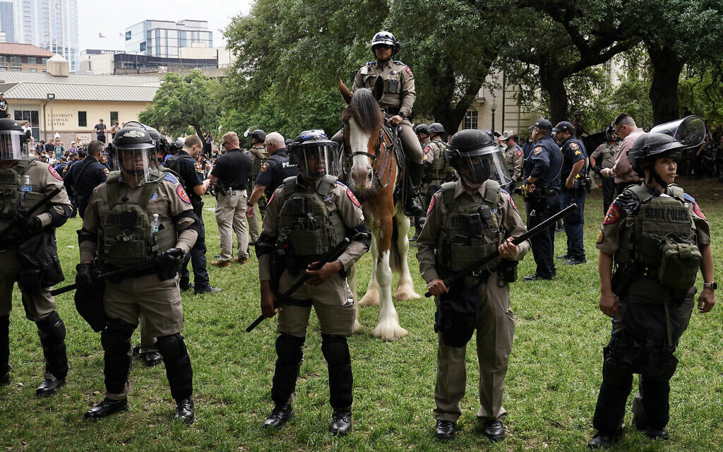 Des policiers de l'État du Texas et d'autres membres des forces de l'ordre surveillant la scène alors que des étudiants pro-palestiniens manifestent contre Israël, sur le campus de l'Université du Texas, à Austin, le 24 avril 2024. (Crédit : Suzanne Cordeiro/AFP) Des policiers de l'État du Texas et d'autres membres des forces de l'ordre surveillant la scène alors que des étudiants pro-palestiniens manifestent contre Israël, sur le campus de l'Université du Texas, à Austin, le 24 avril 2024. (Crédit : Suzanne Cordeiro/AFP)