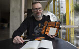 L'artiste autrichien Andreas Joska-Sutanto travaillant sur son projet de transformation du livre "Mein Kampf" d'Adolf Hitler en livre de cuisine, à Vienne, le 25 avril 2024. (Crédit : Alex Halada/AFP)