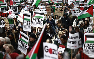 Des manifestants pro-palestiniens brandissant des pancartes et des drapeaux palestiniens pendant une marche anti-Israël aux abords de Westminster, dans le centre de Londres, le 27 avril 2024. (Crédit : Benjamin Cremel/AFP)