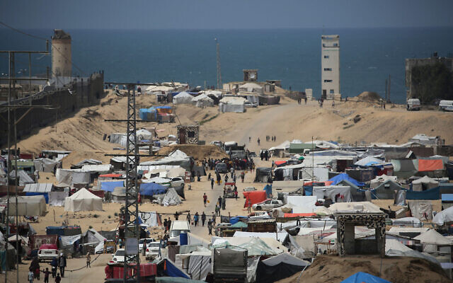 Des Palestiniens marchant dans un camp de déplacés, à Rafah, dans le sud de la bande de Gaza, près de la frontière égyptienne, le 28 avril 2024. (Crédit : AFP)