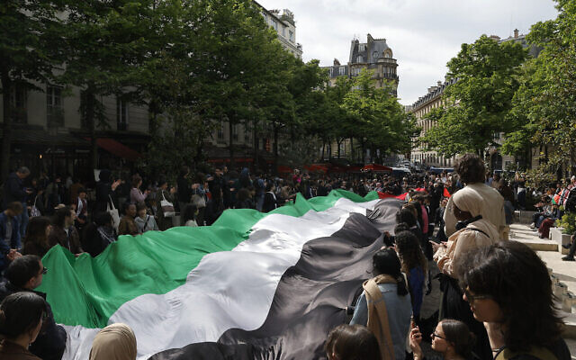Photo d'illustration : Des étudiants arborant un drapeau palestinien géant alors qu'ils participent à un rassemblement en faveur des Palestiniens et contre Israël, à la Sorbonne à Paris, le 29 avril 2024. (Crédit : Geoffroy Van Der Hasselt/AFP)